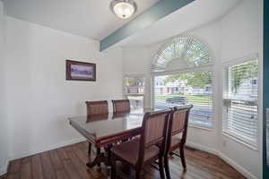 Dining space featuring dark wood-style flooring and baseboards