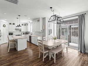 Dining space featuring visible vents, dark wood-style flooring, recessed lighting, a textured ceiling, and a notable chandelier
