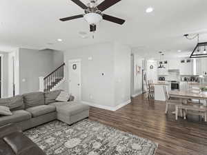 Living area featuring recessed lighting, baseboards, a ceiling fan, and dark wood-style flooring