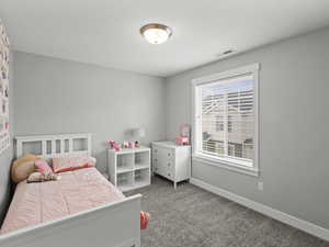Bedroom featuring a textured ceiling, baseboards, visible vents, and carpet
