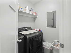 Washroom with laundry area, washing machine and dryer, and electric panel