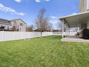 View of exterior with a covered patio, a fenced backyard, and a fire pit