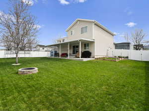 Rear view of house featuring a fire pit, a fenced backyard, a wide gate, and a patio