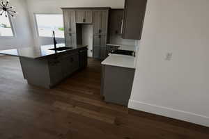 Kitchen with a center island, dark wood-style floors, a sink, and dishwasher