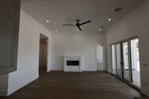 Unfurnished living room with wood finished floors, a fireplace, baseboards, ceiling fan, and recessed lighting