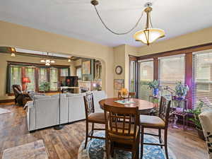 Dining area featuring plenty of natural light, arched walkways, and wood finished floors