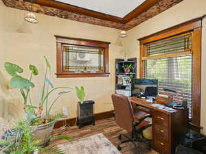 Home office featuring crown molding, baseboards, and wood finished floors