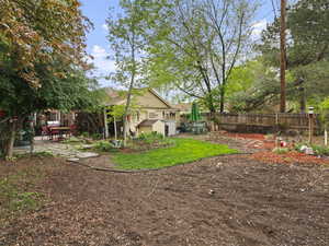 View of yard featuring a fenced backyard, an outbuilding, and a patio area