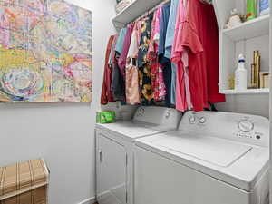 Clothes washing area featuring laundry area and washer and clothes dryer