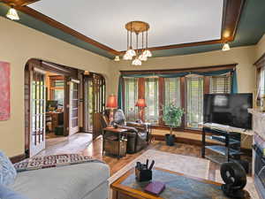 Living room featuring french doors, arched walkways, and wood finished floors