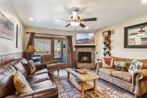 Living area with wood finished floors, ceiling fan, recessed lighting, and a tile fireplace
