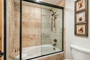 Bathroom featuring tiled shower / bath combo and toilet