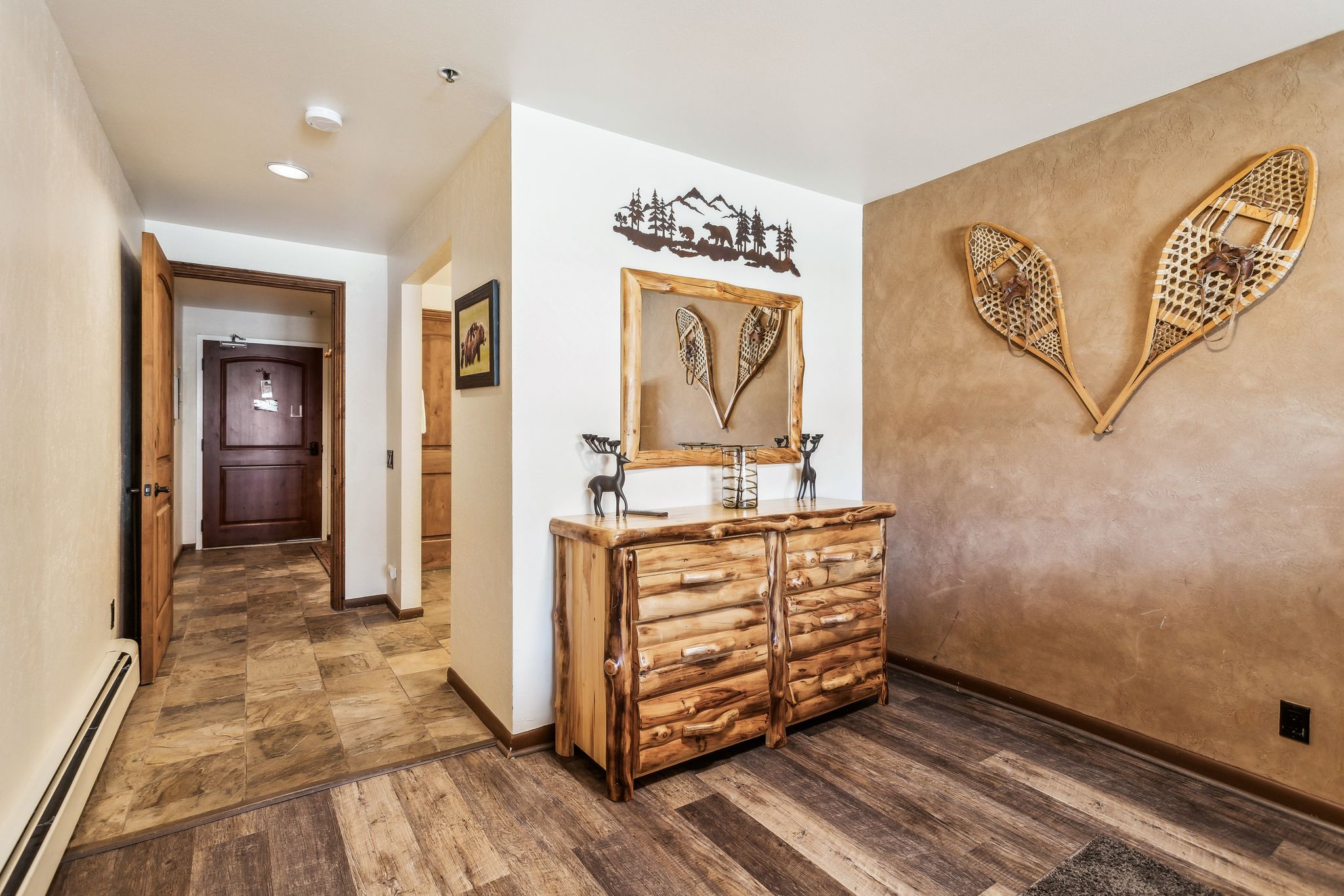 Hall featuring a baseboard heating unit, wood finished floors, and baseboards