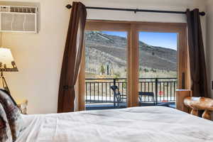 Bedroom featuring access to exterior, a mountain view, and a wall mounted AC