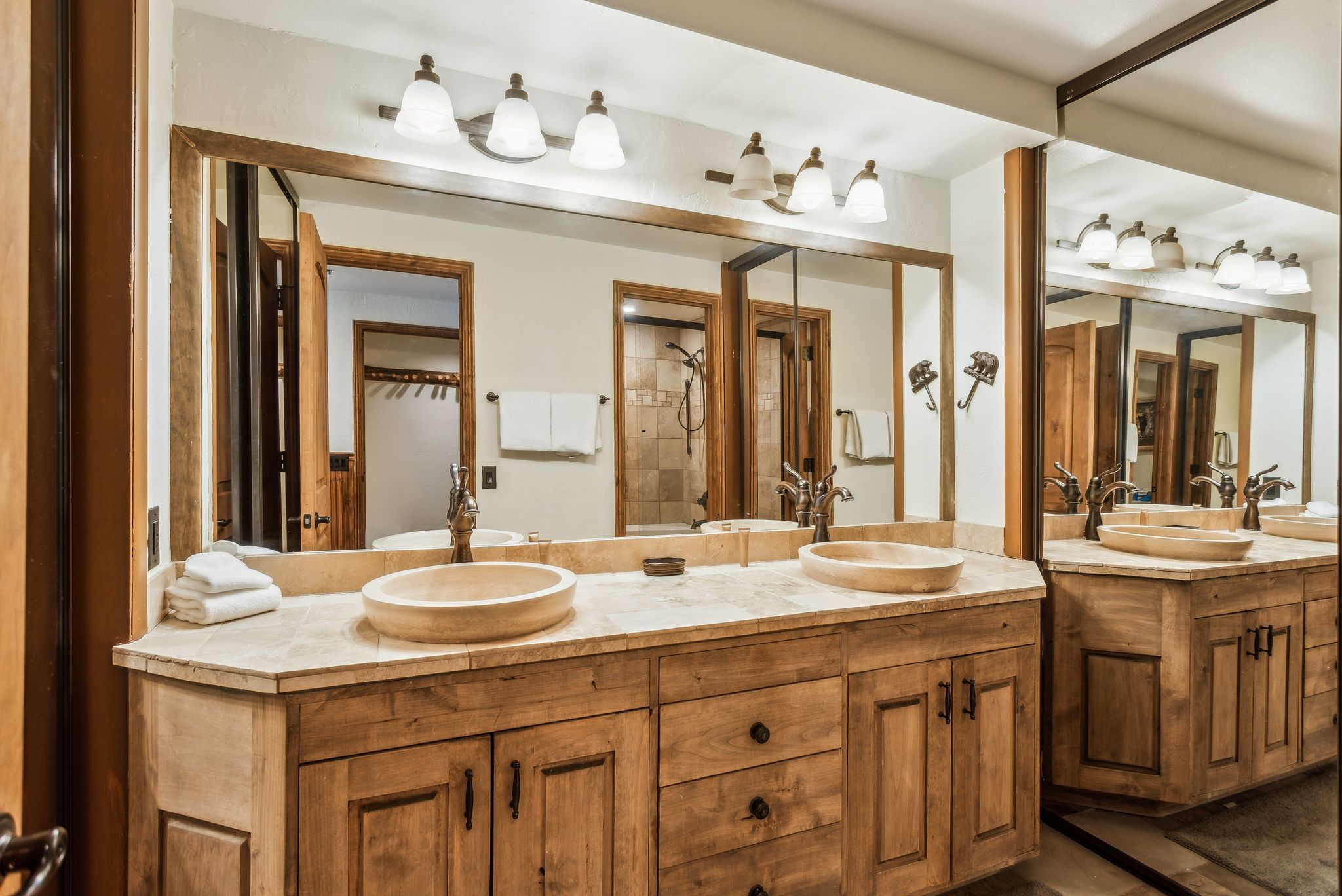 Full bathroom with double vanity, tiled shower, and a sink