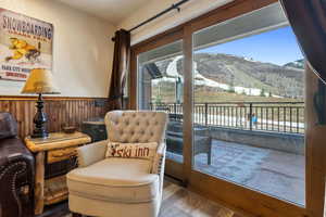 Living area featuring wooden walls, a mountain view, wood finished floors, and wainscoting