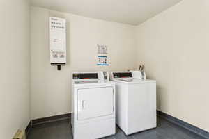 Shared laundry area featuring a baseboard radiator, washer and clothes dryer, and baseboards