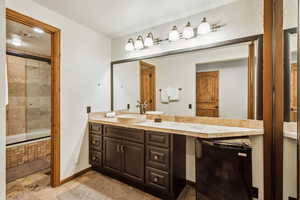 Full bath with baseboards, tiled shower / bath, and vanity