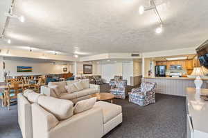 Common area room featuring track lighting, carpet floors, and visible vents