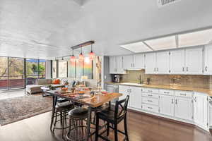 Kitchen featuring open floor plan, dark wood-style floors, a sink, and tasteful backsplash