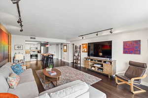 Living room featuring baseboards, visible vents, and track lighting