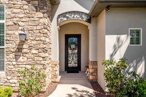 View of exterior entry featuring stucco siding and stone siding