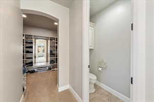 Interior space with baseboards, a walk in closet, and toilet