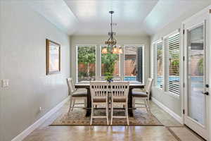 Dining room with visible vents, baseboards, a notable chandelier, and vaulted ceiling