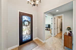 Entrance foyer with recessed lighting, baseboards, a chandelier, and light tile patterned floors