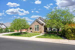 Obstructed view of property featuring a front yard, stucco siding, a tiled roof, and stone siding