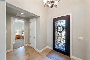 Entryway with baseboards, visible vents, a wealth of natural light, and an inviting chandelier