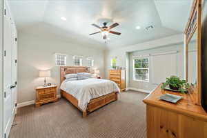 Bedroom featuring visible vents, baseboards, a tray ceiling, and light colored carpet