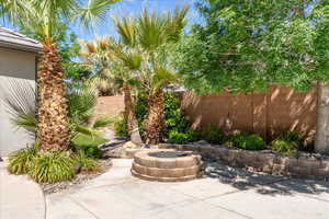 View of patio featuring an outdoor fire pit and fence