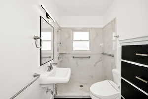 Bathroom with a sink, a shower, and toilet
