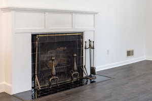 Room details with baseboards, wood finished floors, and visible vents