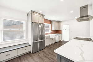 Kitchen featuring dark wood-style flooring, island range hood, a sink, stainless steel appliances, and recessed lighting