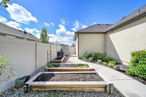 View of yard featuring fence, a gate, and a garden