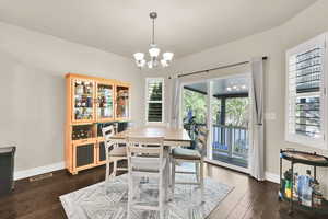 Dining room featuring baseboards, a chandelier, visible vents, and dark wood-type flooring