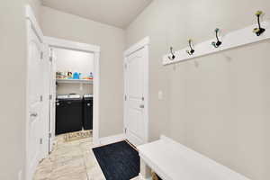 Mudroom with baseboards and washer and dryer