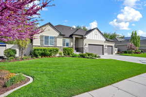 View of front facade with a garage, stucco siding, concrete driveway, and stone siding
