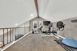 Workout room with baseboards and lofted ceiling