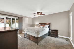 Bedroom with visible vents, baseboards, ceiling fan, and light colored carpet