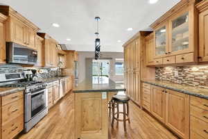 Kitchen with light brown cabinetry, stainless steel appliances, and light wood-type flooring