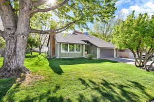Ranch-style house with an attached garage, board and batten siding, fence, and roof with shingles
