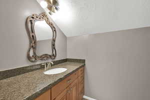 Bathroom featuring vaulted ceiling and vanity
