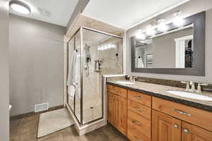 Full bathroom featuring visible vents, a sink, and a marble finish shower