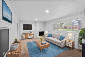 Living area featuring crown molding, carpet floors, and a decorative wall
