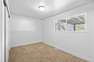 Unfurnished room featuring baseboards, visible vents, and carpet