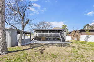 Back of property featuring a patio, a fenced backyard, an outdoor structure, and stairs