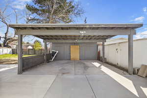 Garage featuring a carport and fence